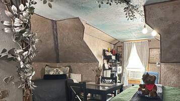 A cozy room with a bed, a chair, a desk, and a teddy bear.