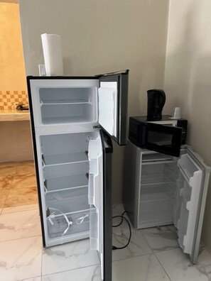 A kitchen with a refrigerator, microwave, and a coffee maker on the countertop. - Beautiful 4-bedroom apartment with AC in Saint Ann's Bay (Saint Ann's Bay)