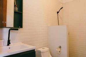 Un baño con un lavabo blanco, un inodoro y una ducha.