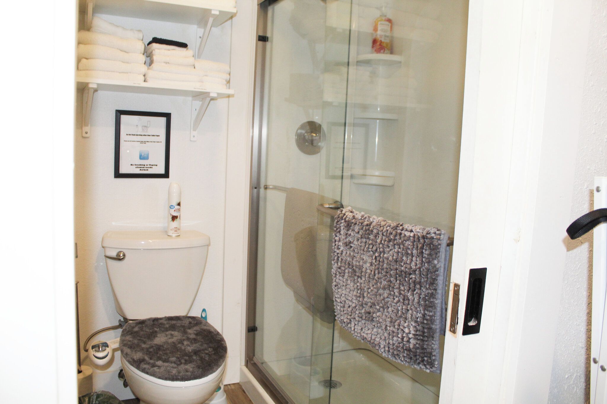 Une salle de bain équipée de toilettes, d’une douche à parois de verre et d’un porte-serviettes.