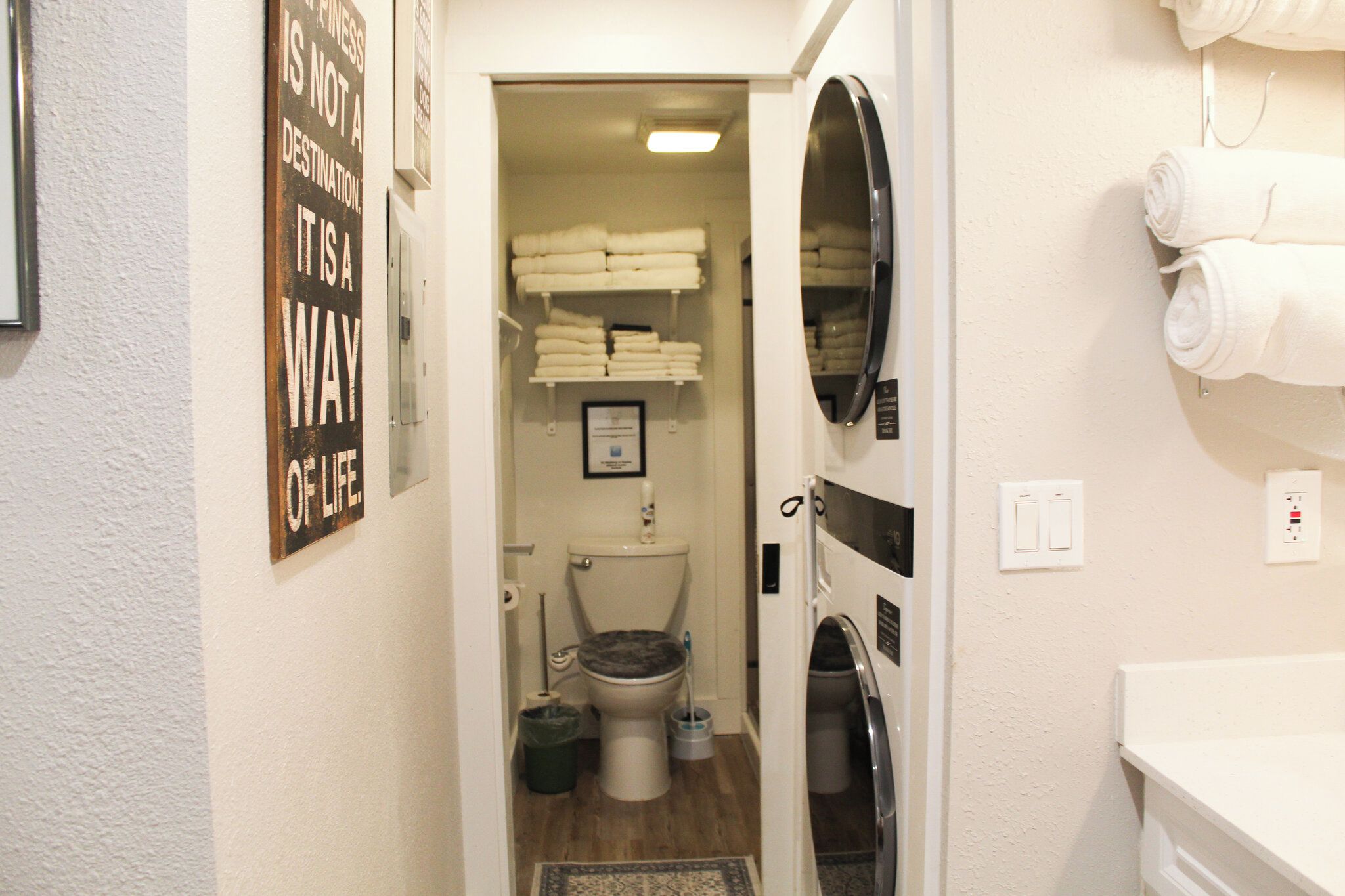 A narrow bathroom with a toilet, a sink, and a towel rack.