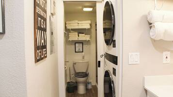 A narrow bathroom with a toilet, a sink, and a towel rack.