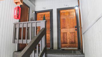 A wooden staircase leading to two doors, each marked with a number.