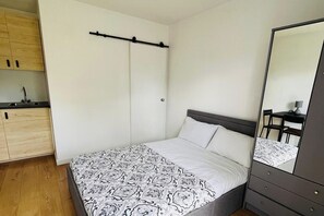 Ein Schlafzimmer mit einem Bett, einem Schminktisch, einem Spiegel und einem Kleiderschrank.