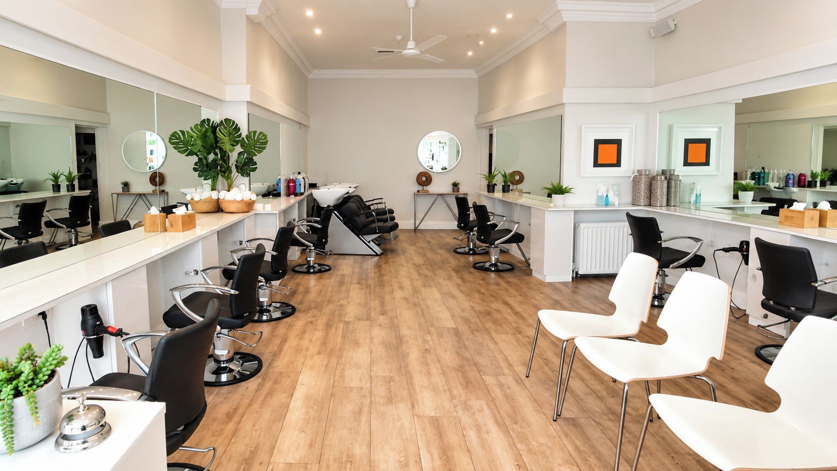 A salon with multiple hairdressing stations, each with a chair and a mirror.
