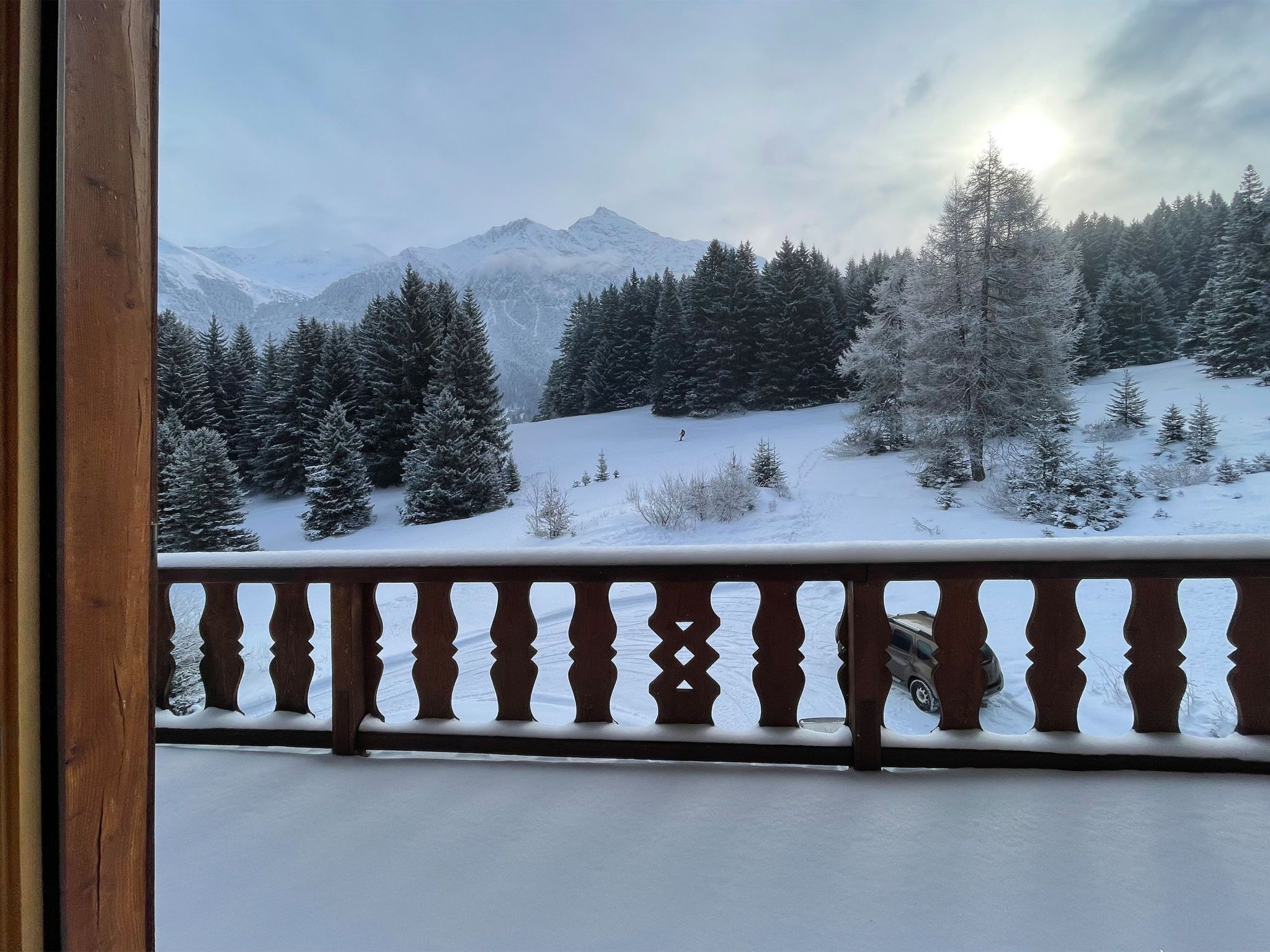 Eine verschneite Berglandschaft mit einem hölzernen Balkon.