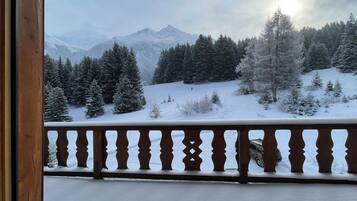 Eine verschneite Berglandschaft mit einem hölzernen Balkon.