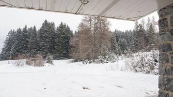 Schneebedeckte Landschaft mit einer Steinmauer und einem Holzdachaufbau.