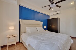 A bedroom with a bed, bedside tables, a ceiling fan, and a wardrobe. - Luxury 2BR Condo in Taguig | Free Parking & Balcony (Taguig)
