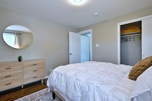 A bedroom with a bed, dresser, mirror, and closet. - Your Chicago Home Between Homes - 4BR Furnished Home (Chicago)