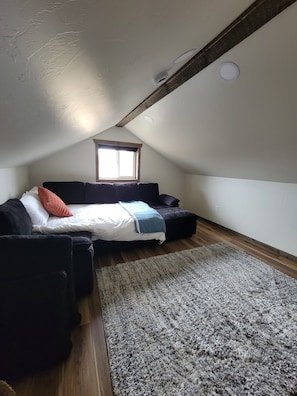 A bedroom with a loft bed, a window, a ceiling fan, and a rug.