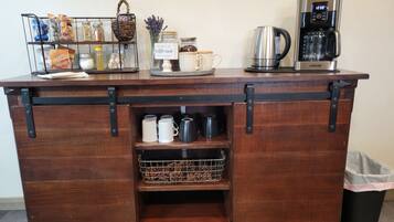 Un comptoir de bar en bois, doté d’étagères de rangement et d’une machine à café.