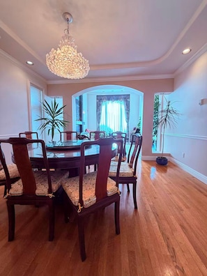 A dining room with a round table, six chairs, and a chandelier. - Richmond Elegant Home-Luxury Stay close to YVR and center (Richmond)