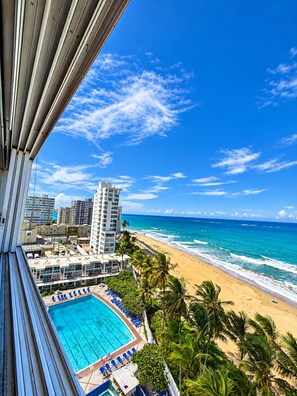 A hotel balcony with a view of a beach and ocean. - Gorgeous Condado 3-Bedroom + 2 Bath w/ OceanView! (San Juan)