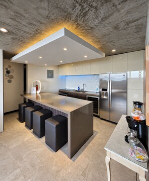 A modern kitchen with a central island, stainless steel appliances, and a minimalist design. - Gorgeous Condado 3-Bedroom + 2 Bath w/ OceanView! (San Juan)