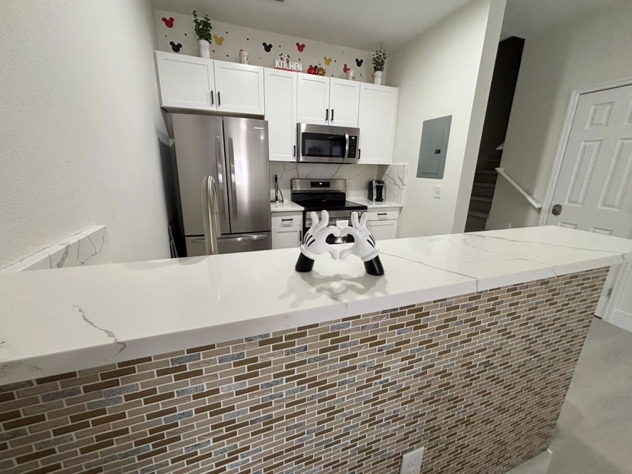 A kitchen with white cabinets, stainless steel appliances, and a white countertop.