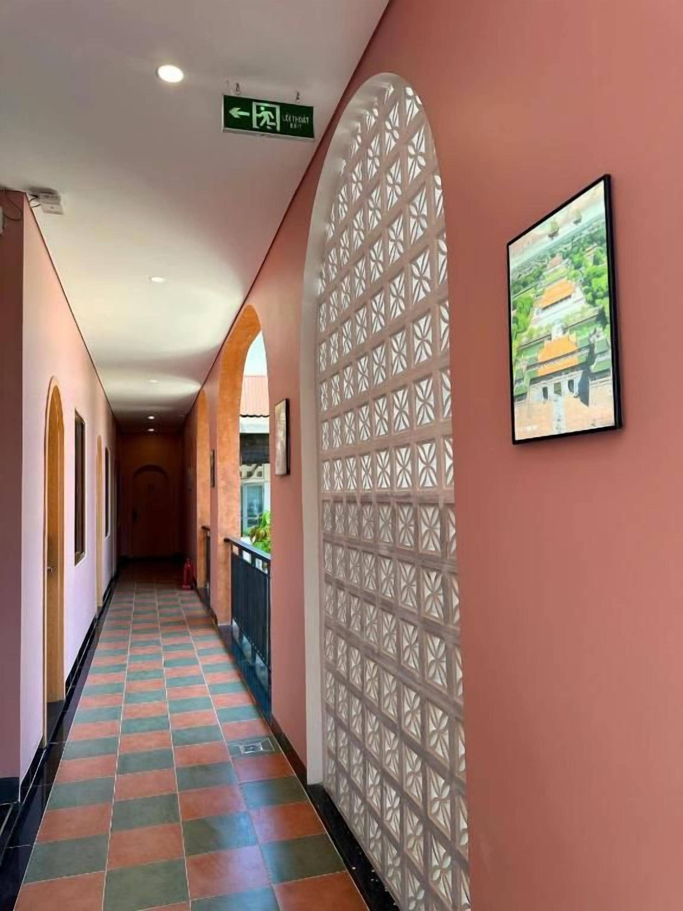 Un pasillo con piso estampado, un panel decorativo en la pared y un cuadro enmarcado.