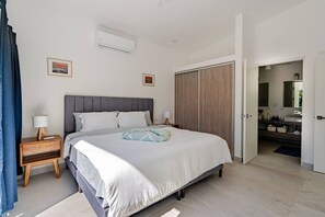 A modern bedroom with a bed, bedside tables, an air conditioning unit, and a wardrobe. - Serene, Contemporary Retreat with Plunge Pool (Playa Avellanas)
