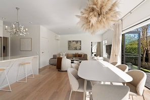Ein modernes Interieur mit Essbereich, einer Couch und einem großen Fenster mit Blick.
