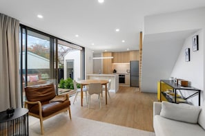 A modern interior with a dining area, kitchen, and seating space. - Modern Town House in the Heart of Merivale (Christchurch)