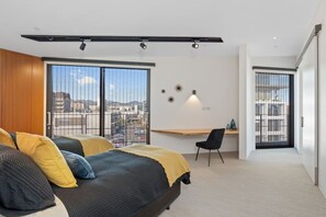 A modern bedroom with a bed, a desk, and a chair. - Luxury Penthouse in the City (Christchurch)