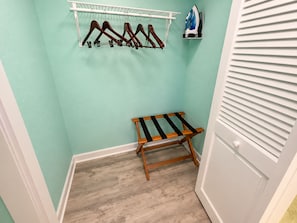 A laundry area with a drying rack, a hanging clothes rack, and an iron. - The Curaçao | Key West Condo with Pool, Balcony, & Sunset Views (Key West)