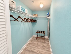 A laundry room with a wooden bench, a white shelf with towels, and a hanging rack. - The Curaçao | Key West Condo with Pool, Balcony, & Sunset Views (Key West)