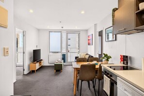 Ein modernes Apartment mit Essbereich, Küche und einem großen Fenster.