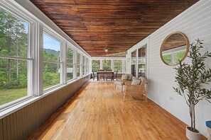 A long room with wooden flooring, large windows, and a ceiling with wooden beams. - Lake Sunapee Swim & Ski Retreat (Newbury)
