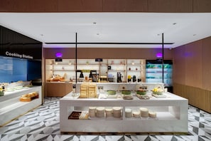 A modern kitchen area with a central island displaying various food items and kitchenware.