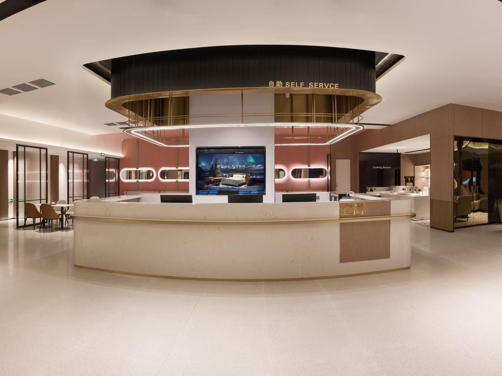 Eine moderne Hotellobby mit einer Rezeption, einem großen Bildschirm und einer Selbstbedienungs-Kiosk.