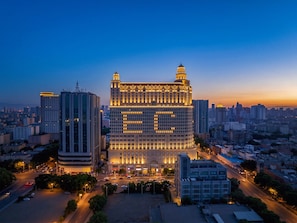Un grand bâtiment à plusieurs étages, doté d’un dôme central imposant et d’une façade symétrique.