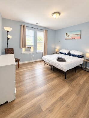 A bedroom with a bed, a chair, a desk, and a window with curtains. - Chic 3-bedroom apartment with AC in Atlantic City (Atlantic City)