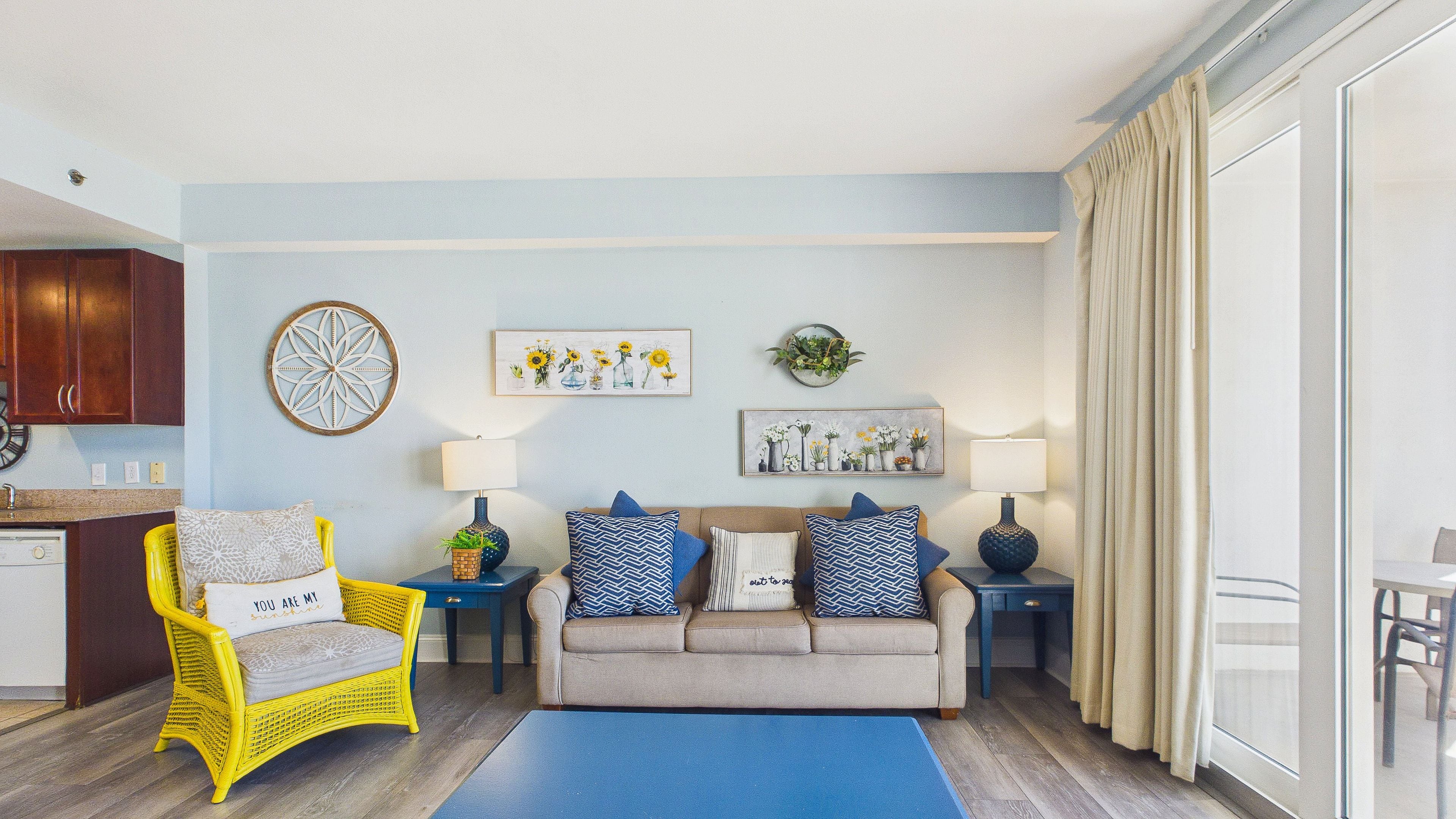 A living room with a sofa, chairs, a coffee table, and a dining area with a table and chairs.