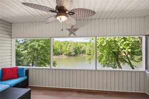 A room with a ceiling fan, a star decoration, and a view of a lake surrounded by trees. - N Lake Dr on Whitewater Lake (Salem)