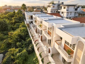 A modern multi-story building with balconies, a rooftop garden, and a view of the surrounding neighborhood. - Dimora Bali Resort (Badung)