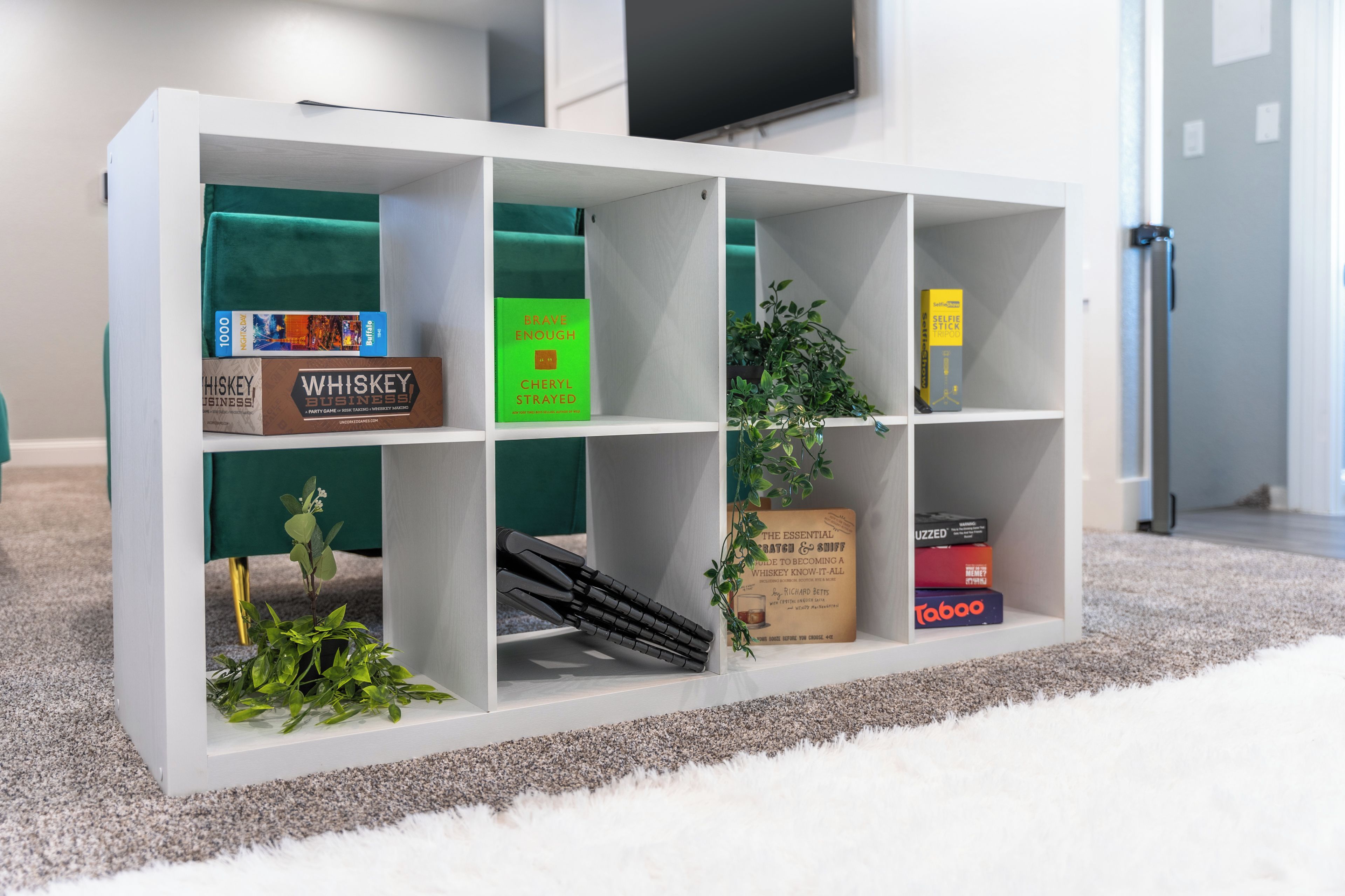 Ein weißes Regal mit verschiedenen Büchern und Dekorationselementen.