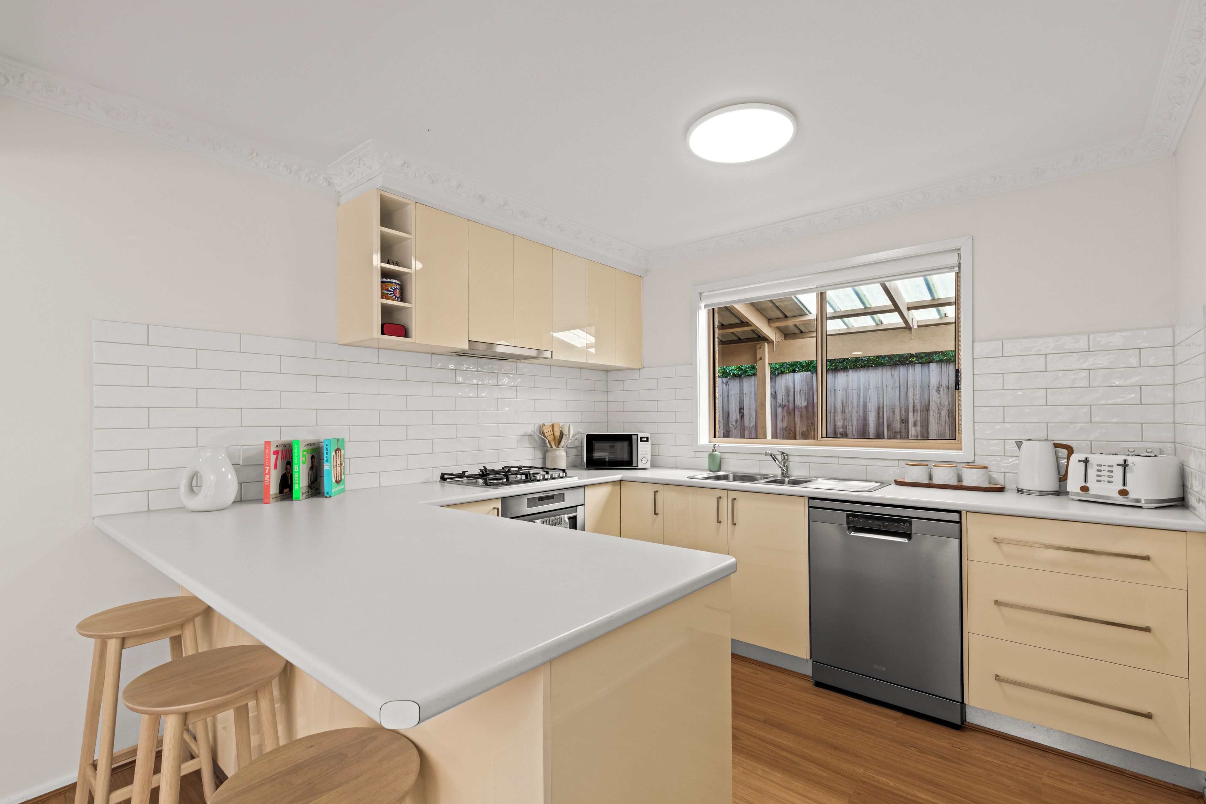 Una cucina moderna con isola centrale, elettrodomestici integrati e una finestra vista.