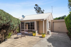 A residential property with a covered patio, satellite dish, and a garage.