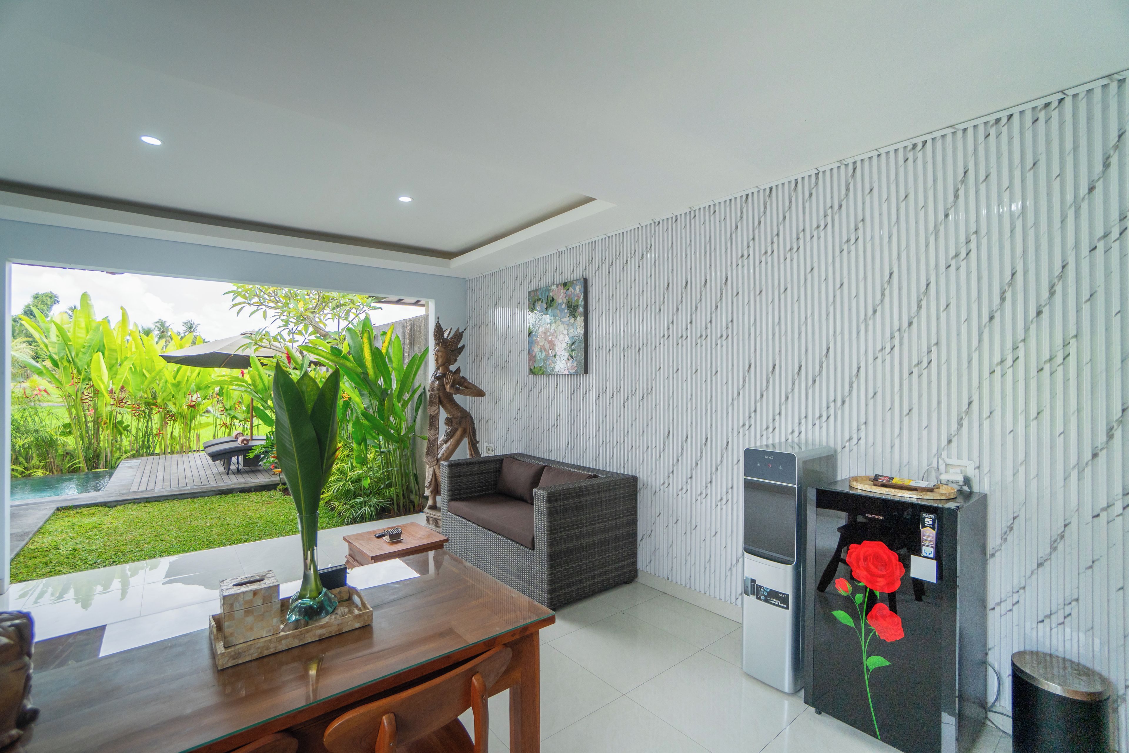 Una sala de estar moderna con comedor, sofá, mesa de centro y refrigerador.