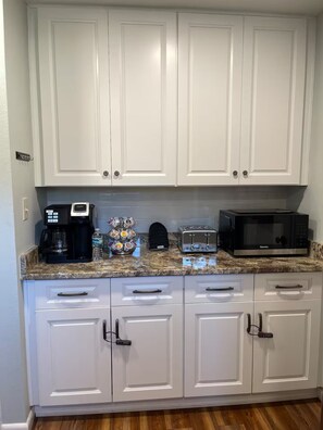 A kitchen with white cabinets, a coffee maker, a toaster, and a microwave. - 20 Acre Ranch - 40 min to 30A! (DeFuniak Springs)