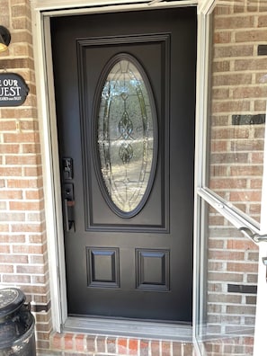 A black door with a frosted glass window and a small doorbell. - 20 Acre Ranch - 40 min to 30A! (DeFuniak Springs)
