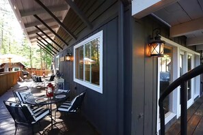 An outdoor patio with tables and chairs, a wooden deck, and a covered area with a railing. - Secluded Writer's Retreat | Trails Out the Door (Pollock Pines)