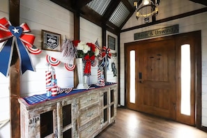 A wooden reception desk with patriotic decorations, a sign reading 'Relax & Unwind,' and a framed sign with the text 'Mountains Calling.' - Secluded Writer's Retreat | Trails Out the Door (Pollock Pines)