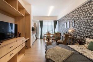 A modern living room with a flat-screen TV, a sofa, a coffee table, and a dining area with chairs and a table. - Myla - Loft 09A Near Centro Historico (Mexico City)