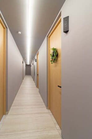 A long, narrow hallway with wooden doors and a light-colored floor. - Myla - Loft 09A Near Centro Historico (Mexico City)