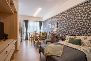 Une chambre moderne avec un lit, un bureau et un coin repas.