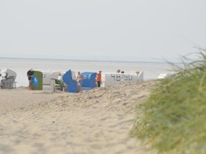 A beach with tents and a few people. - Holiday Apartment With 1 Bedroom (Norden)