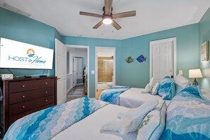 A bedroom with two beds, a wooden dresser, a ceiling fan, and a bathroom visible through an open door. - Pet-Friendly Villa Near Van Der Meer Tennis & ½ Mile to South Forest Beach (Hilton Head Island)