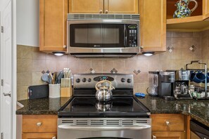 A kitchen with a stainless steel stove, a microwave above it, and a coffee maker on the counter. - Pet-Friendly Villa Near Van Der Meer Tennis & ½ Mile to South Forest Beach (Hilton Head Island)